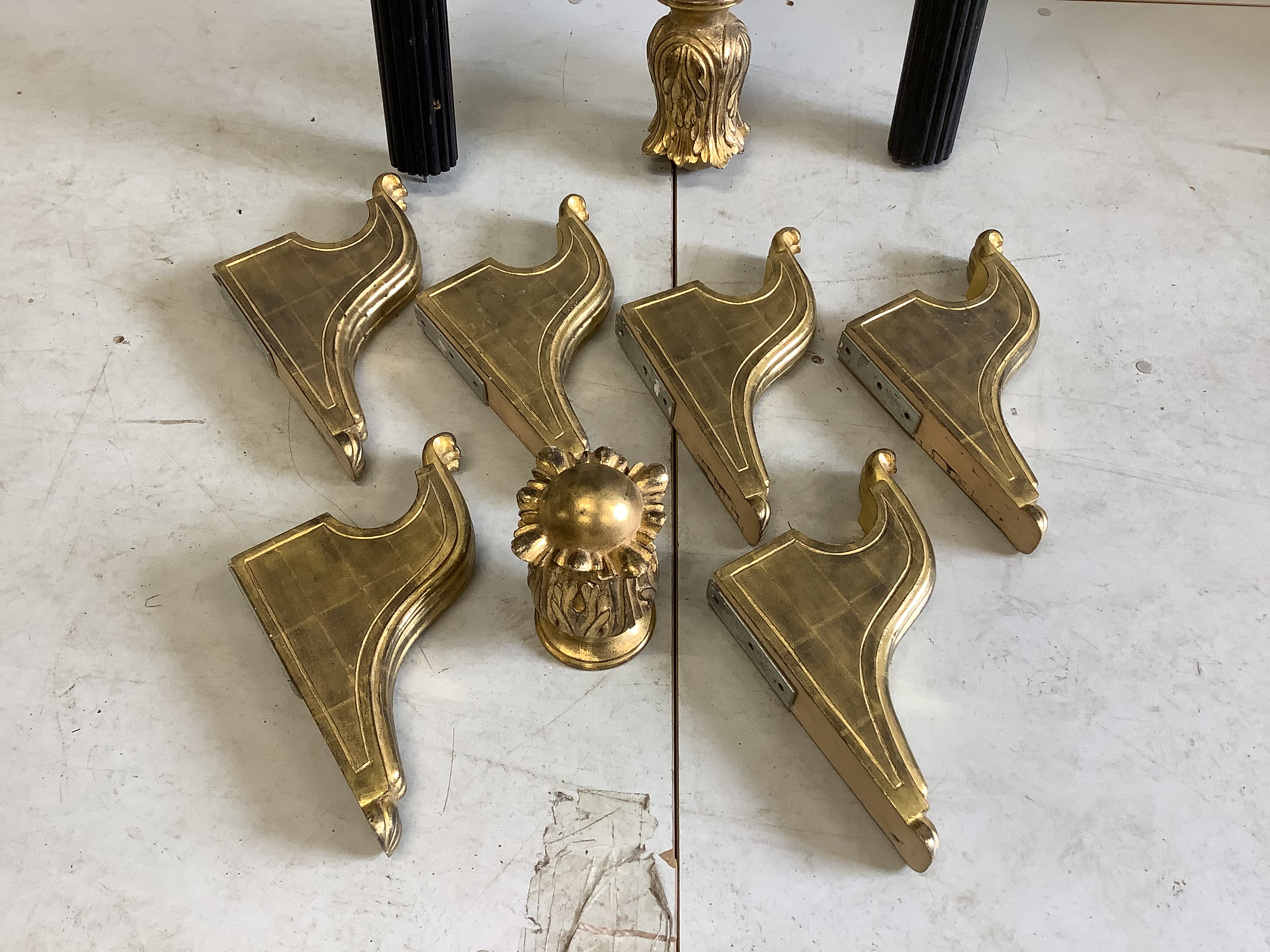 A set of three Regency style carved giltwood and ebonised curtain poles with brackets, largest 198cm